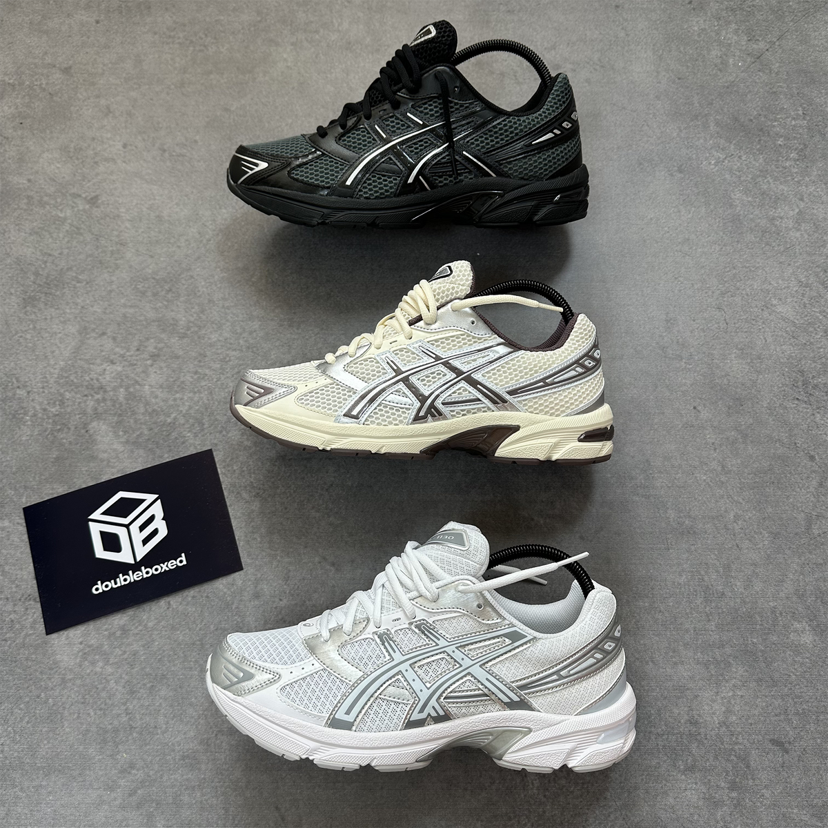 Three ASICS GEL-1130 colourways photographed on a grey floor at Double Boxed